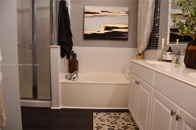 bathroom featuring vanity, wood-type flooring, and plus walk in shower