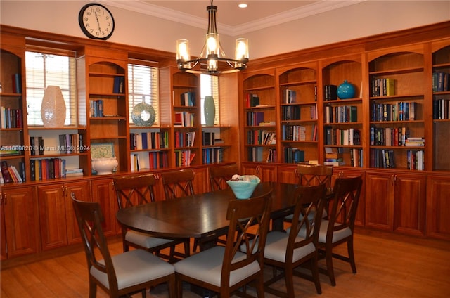 dining room with light hardwood / wood-style floors, crown molding, and an inviting chandelier