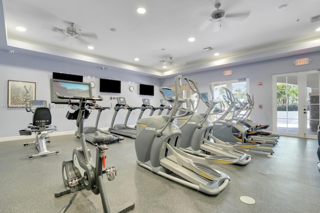 exercise room with french doors, a tray ceiling, and ceiling fan