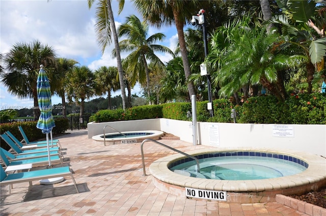 view of swimming pool with a patio and a hot tub