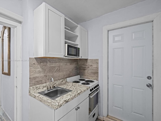 kitchen with decorative backsplash, sink, light stone countertops, white electric stove, and white cabinets