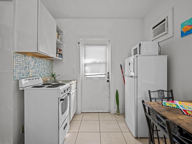 kitchen with white appliances, tasteful backsplash, sink, white cabinets, and light tile patterned floors