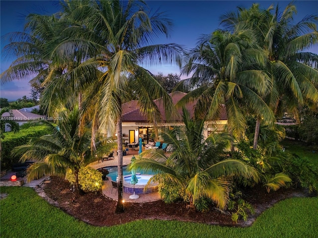 pool at dusk with a patio area