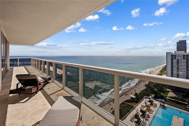 balcony with a water view and a view of the beach