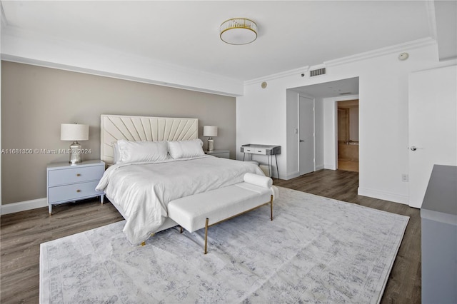 bedroom featuring crown molding and dark hardwood / wood-style floors