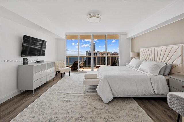 bedroom featuring dark wood-type flooring, expansive windows, and access to exterior