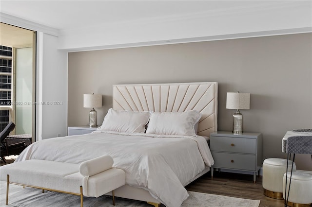 bedroom featuring ornamental molding and dark hardwood / wood-style flooring