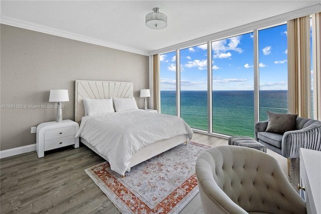 bedroom with crown molding, dark hardwood / wood-style floors, and a water view