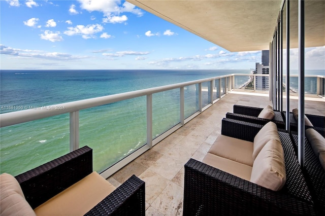 balcony with a water view, an outdoor living space, and baseboard heating