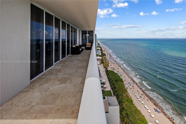 balcony featuring a water view and a beach view