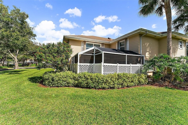 back of house with a yard and a sunroom