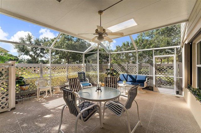 view of patio with ceiling fan and glass enclosure