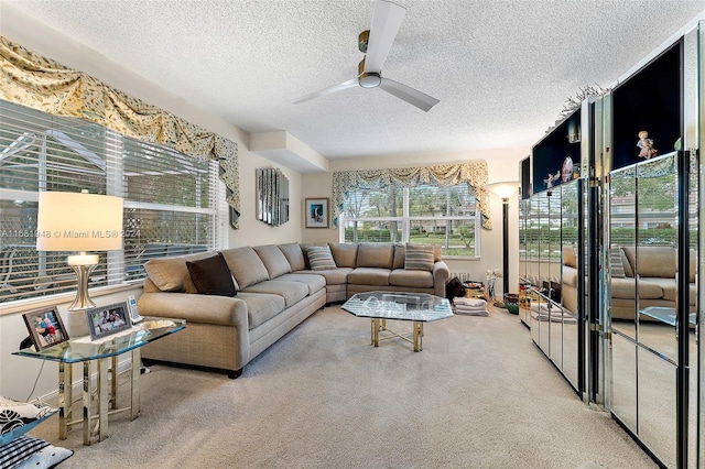 carpeted living room featuring ceiling fan and a textured ceiling