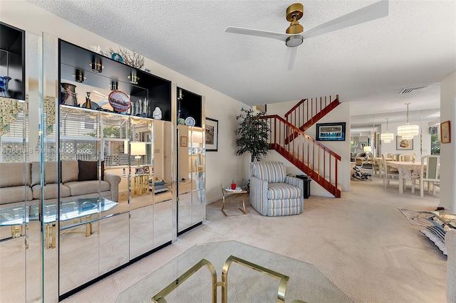 carpeted living room featuring ceiling fan and a textured ceiling