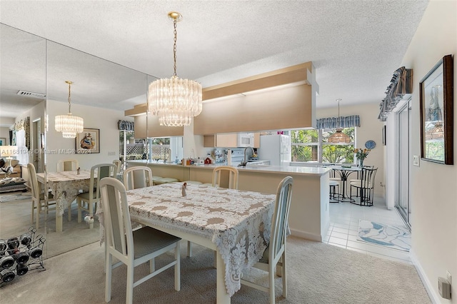 carpeted dining area featuring a wealth of natural light, sink, a notable chandelier, and a textured ceiling