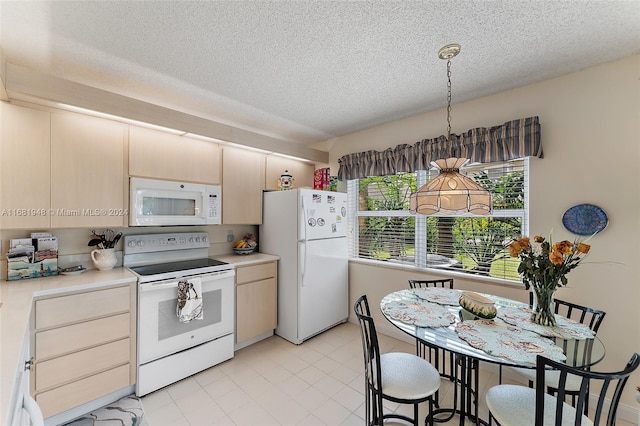 kitchen with pendant lighting, a textured ceiling, and white appliances