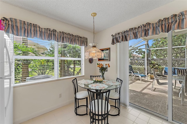 tiled dining area with a textured ceiling