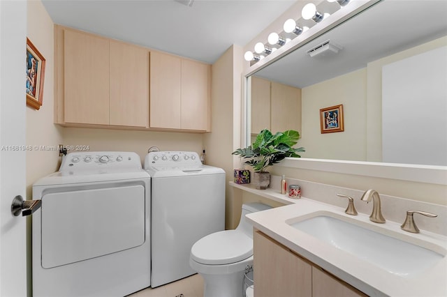 bathroom featuring toilet, vanity, washing machine and dryer, and tile patterned flooring