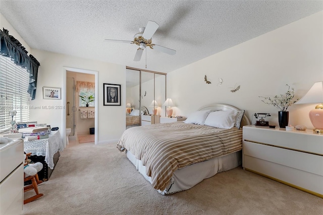 carpeted bedroom featuring connected bathroom, a textured ceiling, a closet, and ceiling fan