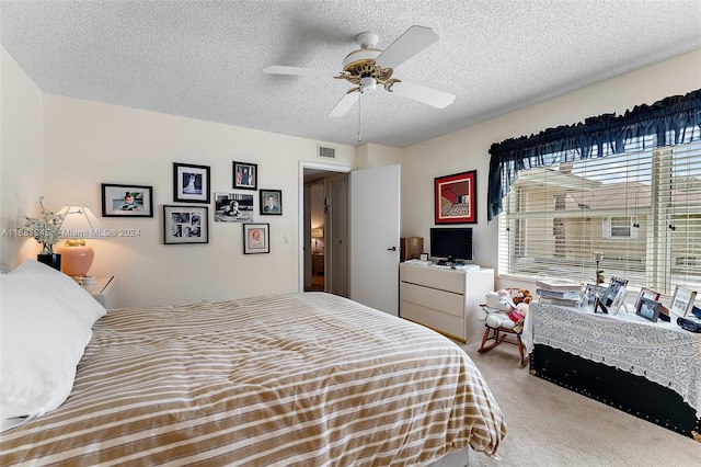 carpeted bedroom featuring ceiling fan and a textured ceiling