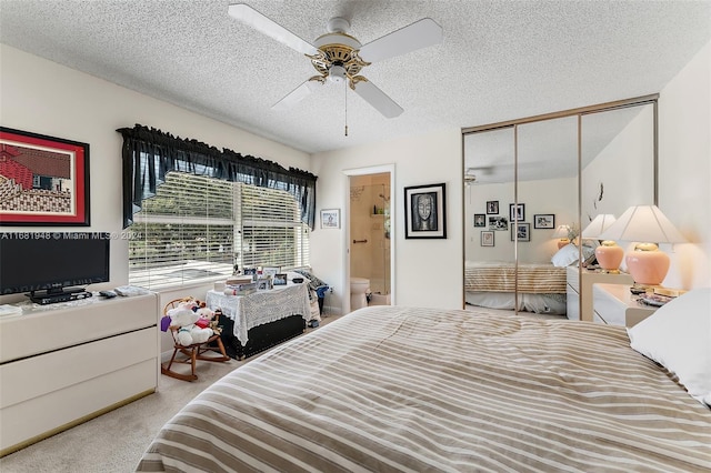 carpeted bedroom with a closet, ceiling fan, a textured ceiling, and ensuite bathroom