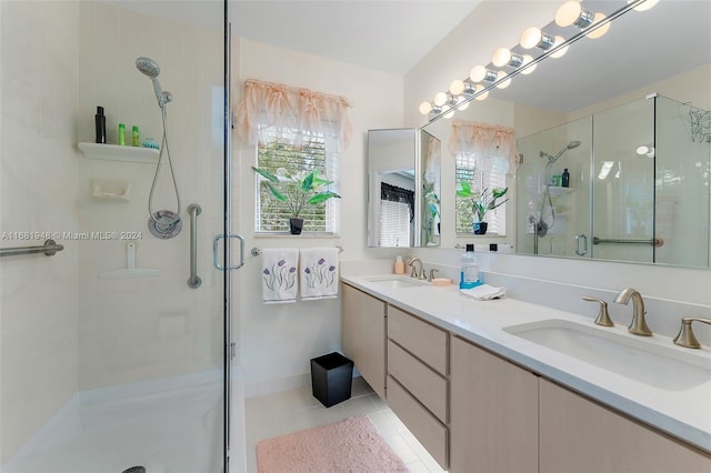 bathroom with a shower with door, vanity, and tile patterned flooring