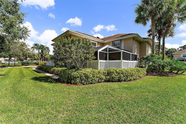 view of property exterior with a yard and a sunroom