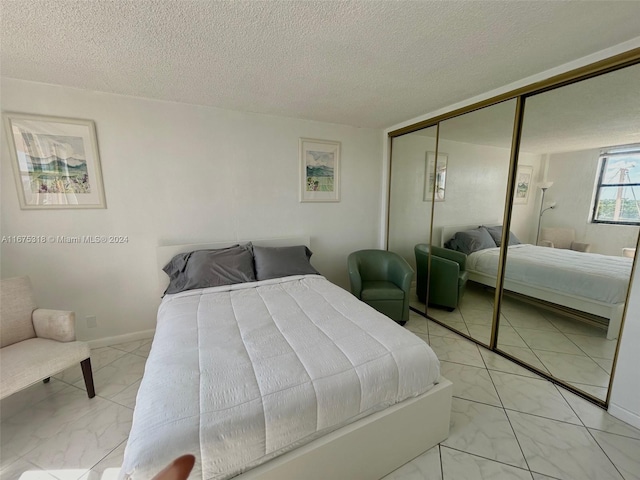 bedroom featuring a textured ceiling and a closet