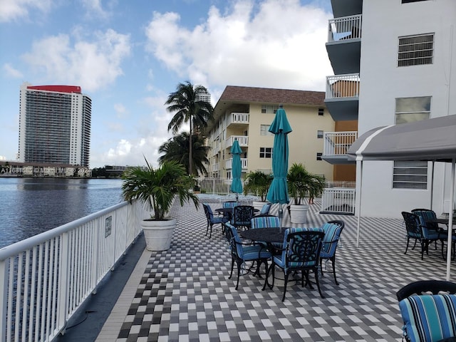 view of patio featuring a water view and a balcony