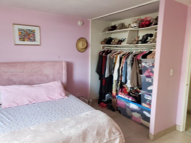 tiled bedroom featuring a closet