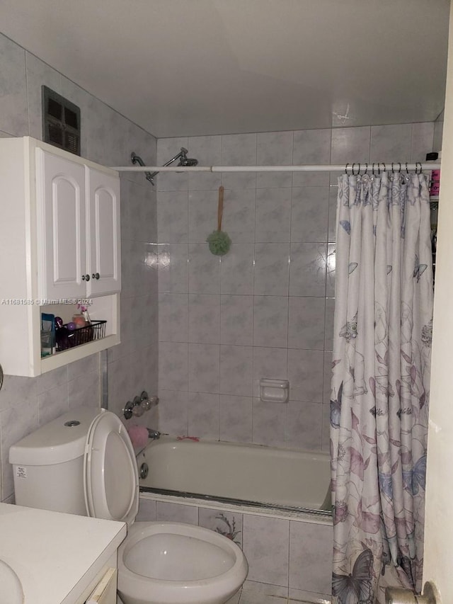 full bathroom featuring toilet, vanity, tile walls, and shower / tub combo