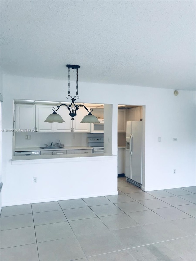 interior space with a textured ceiling, a chandelier, decorative light fixtures, tile patterned floors, and white appliances