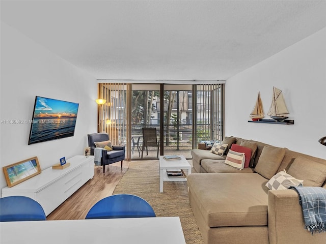 living room featuring hardwood / wood-style floors, a wall of windows, and a textured ceiling