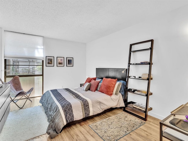 bedroom featuring a textured ceiling and light hardwood / wood-style floors