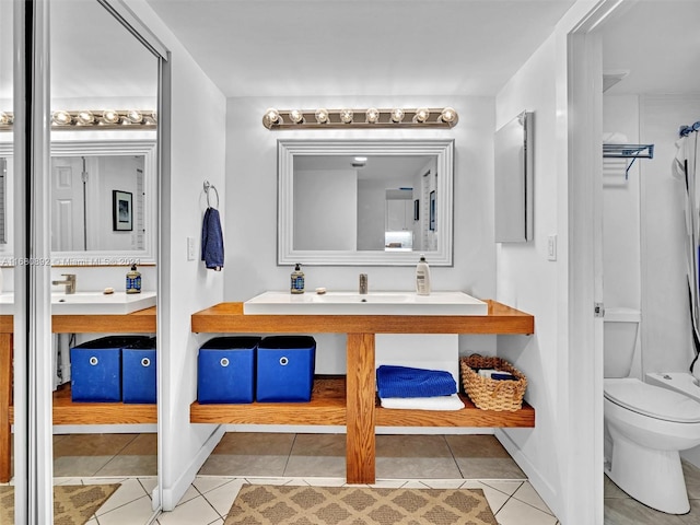 bathroom with vanity, toilet, and tile patterned flooring