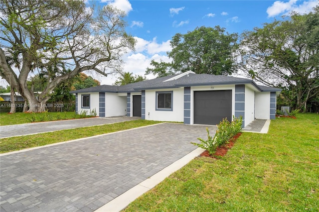 single story home featuring a garage and a front lawn