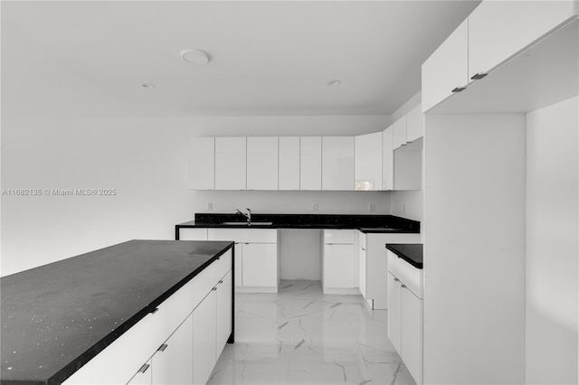 kitchen featuring white cabinetry and sink