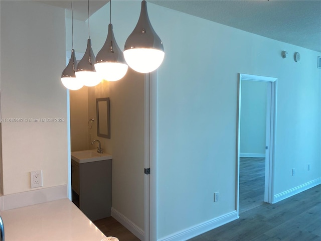 bathroom with a textured ceiling, hardwood / wood-style flooring, and sink