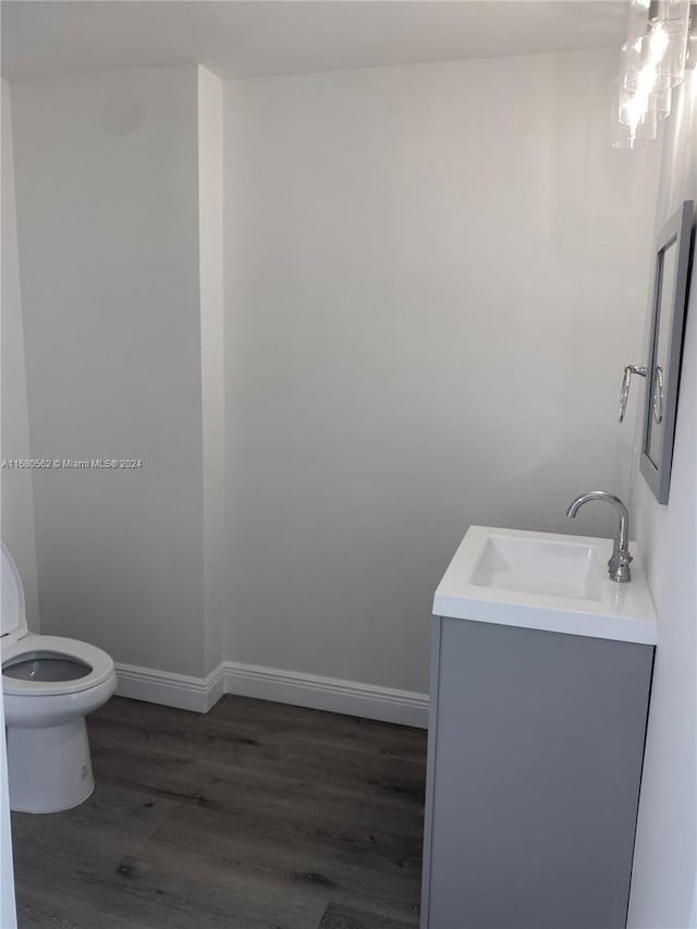 bathroom with vanity, toilet, and hardwood / wood-style flooring