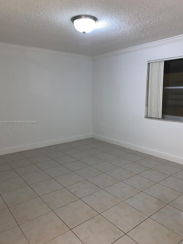 empty room featuring crown molding, light tile patterned flooring, and a textured ceiling