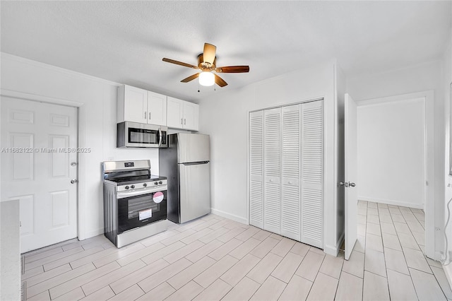 kitchen with ceiling fan, white cabinetry, a textured ceiling, and appliances with stainless steel finishes