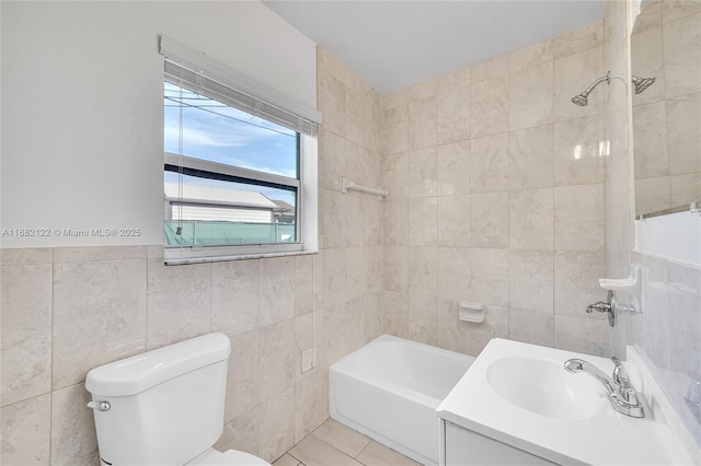 full bathroom featuring vanity, tiled shower / bath combo, tile walls, tile patterned flooring, and toilet