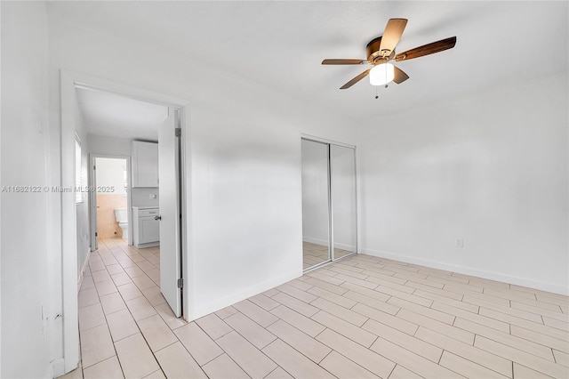 unfurnished bedroom featuring ceiling fan and a closet