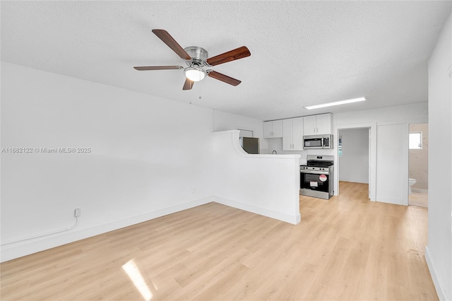 unfurnished living room with ceiling fan, light hardwood / wood-style floors, and a textured ceiling