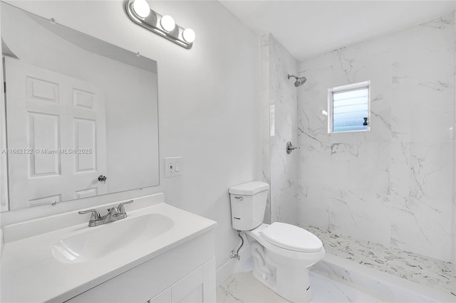 bathroom with tiled shower, vanity, and toilet