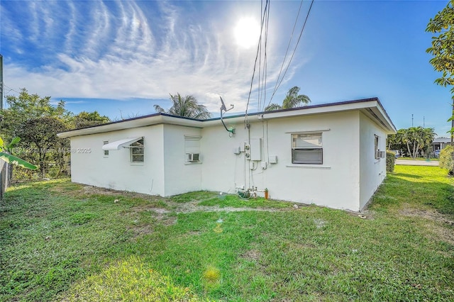 rear view of house with a yard and cooling unit