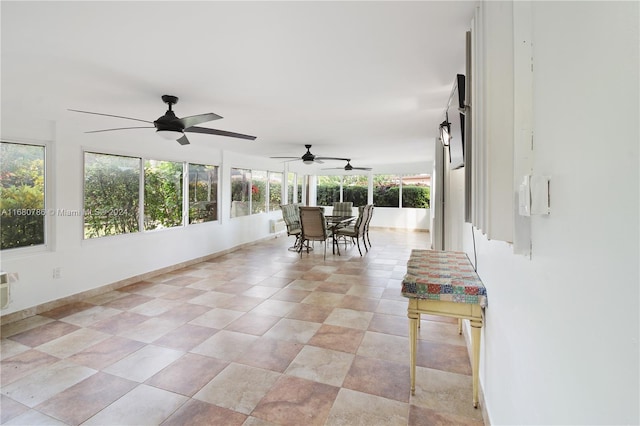 unfurnished sunroom featuring a wealth of natural light and ceiling fan