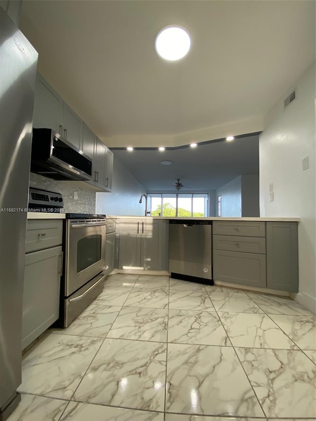 kitchen featuring tasteful backsplash, sink, stainless steel appliances, gray cabinets, and extractor fan