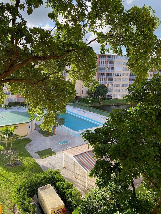 view of pool featuring a patio and a yard