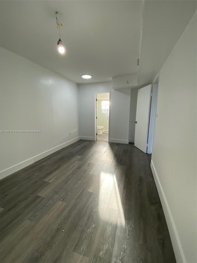 unfurnished room featuring dark wood-type flooring